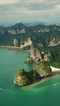 Aerial view of tropical turquoise lagoon, beach between rocks and islands, Krabi, Railay, Thailand. Vertical video