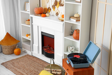 Interior of living room with pumpkins, fireplace and shelf units