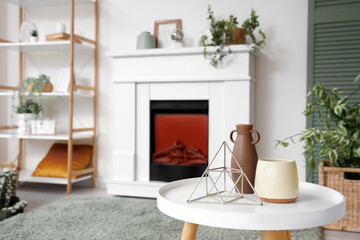 Interior of living room with electric fireplace, shelf unit and houseplants