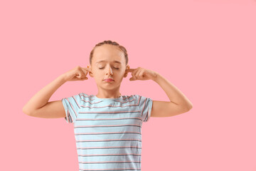 Little girl covering ears on pink background