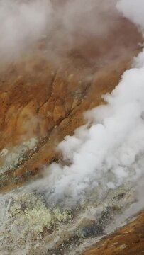 Aerial view of fumaroles in crater of active Mutnovsky volcano, Kamchatka, Russia. Vertical video