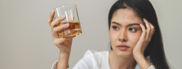 Alcoholism drunk, sad asian young woman hand holding glass of alcohol or whiskey, alone depressed...