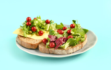 Plate of sandwiches with fresh herbs, cheese and Christmas balls on color background
