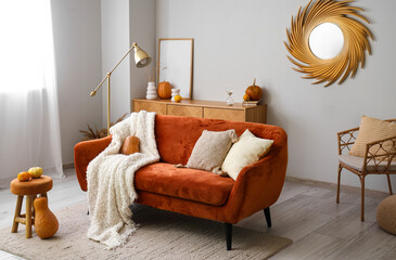 Interior of living room with pumpkins and red sofa