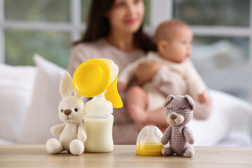 Breast pump with toys on table in bedroom, closeup