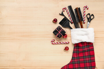 Composition with Christmas sock, hairdresser's accessories and gift box on wooden background