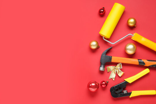 Composition with builder's tools and Christmas decorations on red background