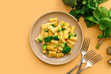 Plate of tasty pasta with broccoli on beige background