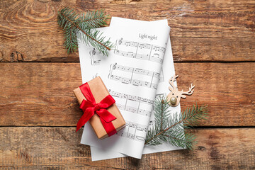 Composition with music sheets, Christmas gift and fir branches on wooden background