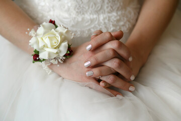 Female hands on wedding dress.