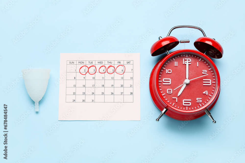 Wall mural menstrual cup, calendar and alarm clock on color background