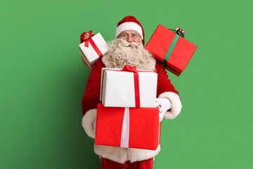Santa Claus with Christmas gifts on green background