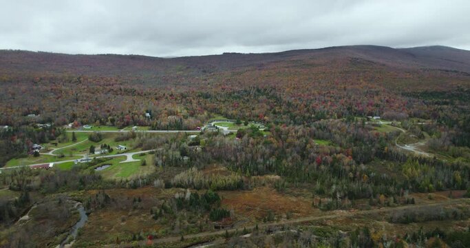 Aerial view of residential area near colorful fall forest on hillside