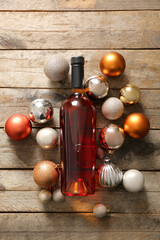 Bottle of wine and Christmas balls on wooden background