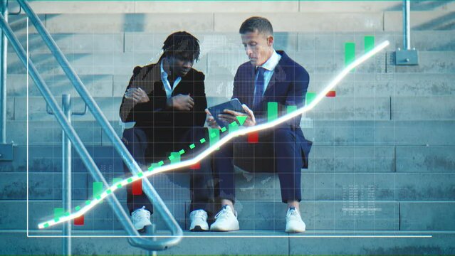 Digital positive curve chart with financial development in front of male duo of business partners discussing latest data sets on tablet sitting on staircase step