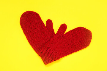 Stylish warm mittens on yellow background