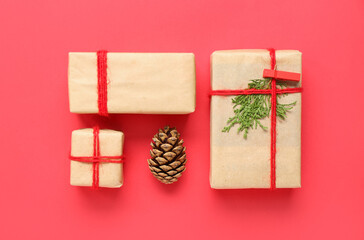 Pine cone and Christmas gift boxes on red background