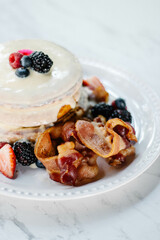 Hot cakes cubiertos de crema pastelera, frutos rojos y tocino 