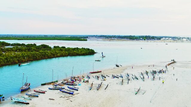 Beautiful African Harbor scenery with people and pirogues. Aerial view of boats sailing the blue azure river. Ships leaving the port. Green coast. Calm African Landscape scenery.