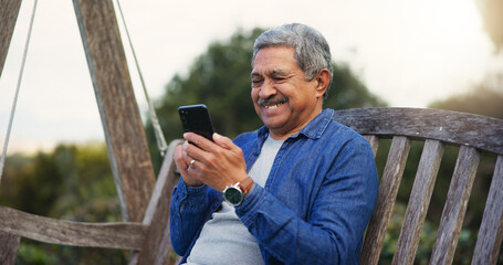 Senior man, happy and smartphone on bench for communication, connection and social media in park....