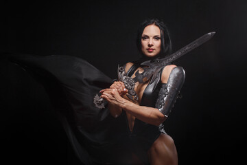 Fantasy woman warrior in armor with sword on black