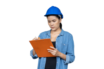 Portrait of female worker wearing safety uniform, helmet standing and working with clipboard on white background