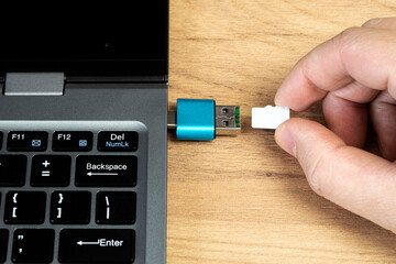 usb flash drive adapter micro sd card connection to laptop. micro sd card in man's hand - obrazy, fototapety, plakaty