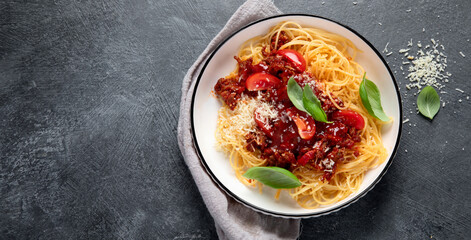 Pasta spaghetti bolognese with minced beef sauce, tomatoes, parmesan cheese and fresh basil in a plate. Italian food