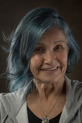 radiant senior woman is embracing her age and individuality with her stylish blue hair. She's a reminder that you're never too old to have fun and express yourself - 678507581