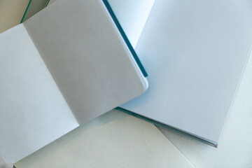 Open notebook and books on white blank paper, flat lay, mock up.