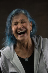 portrait of a radiant senior woman lost in a moment of infectious laughter. Blue-dyed hair youthful spirit ageless beauty - 678509986