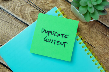 Concept of Duplicate Content write on sticky notes isolated on Wooden Table.