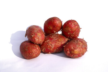 Red potatoes on a white background. Several tubers of red-skinned potatoes close-up, horizontal photo.
