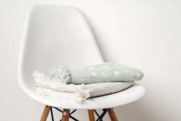 Two baby blankets on white chair close up - obrazy, fototapety, plakaty