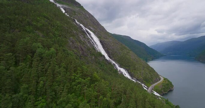 Side aerial view of impressive Langfoss falls cascading down rocky mountainside
