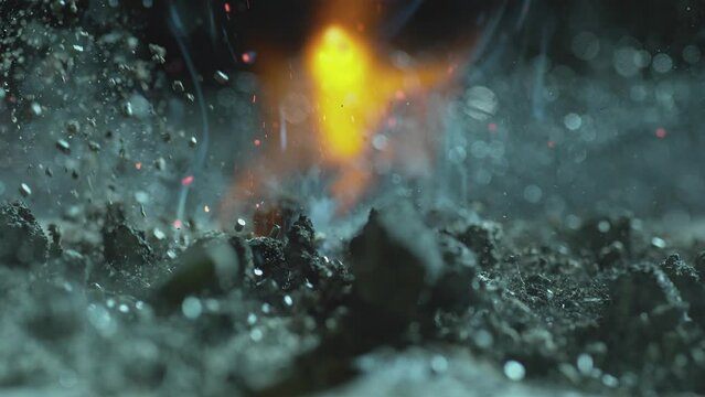 As a flam burns a pile of crumbled charcoal is tossed in the air and the fire grows larger