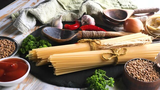 Pasta with vegetables and spices, on the table, on an old background.