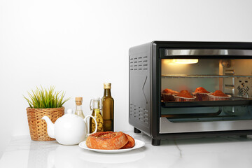 Mini electric oven with baked cakes inside