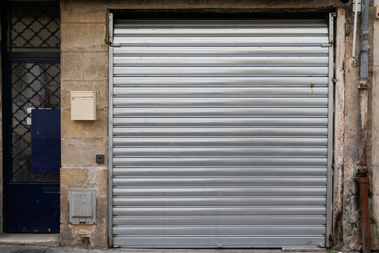 Old store facade ancient storefront with metallic closed curtains in concept abandoned shop business