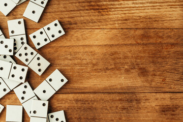 Domino game on brown wooden background close up