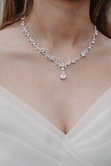 close-up of the necklace on the neck of the bride in a white dress - obrazy, fototapety, plakaty