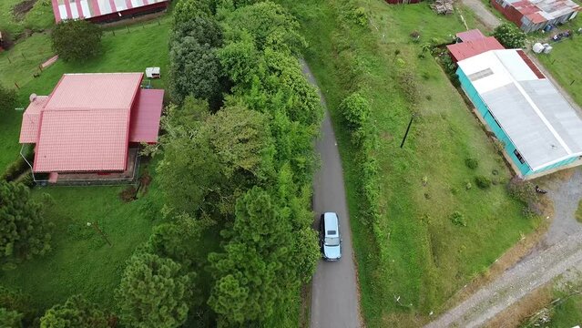 green mountains, driving through mountains in modern SUV car, aerial video, drone, driving in foggy