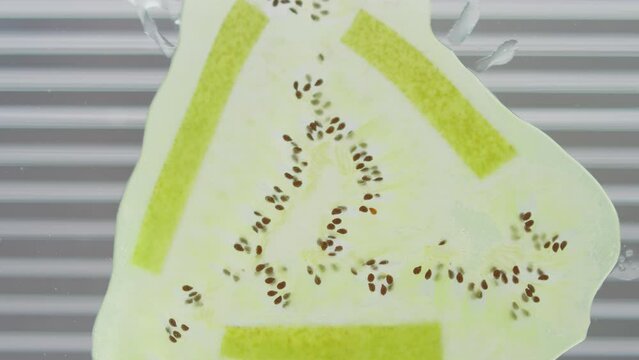 A Piece Of Kiwi Fruit Drops And Splatters