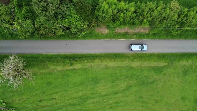 driving through mountains in modern SUV car, aerial video, drone, driving in foggy green mountains, SUV