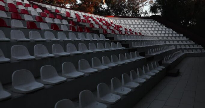 Empty seats in stands of the arena or auditorium. Rows of red and white seats in a stadium without spectators