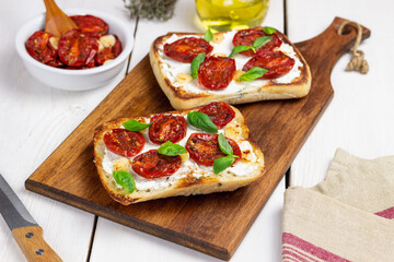 Ciabatta with sun-dried tomatoes, white cheese and basil. Italian food. Vegetarian food.