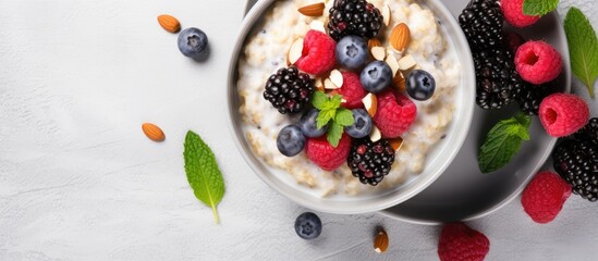Top view of a healthy breakfast or dessert consisting of sweet rice porridge accompanied by berries nuts coconut chips bread and butter Cutlery is included