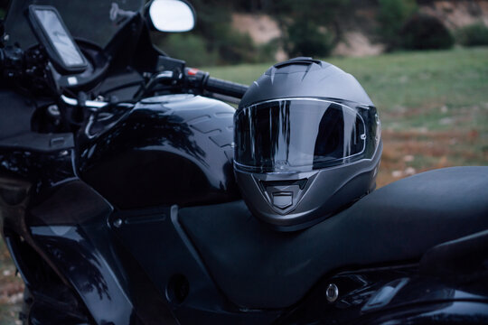 Motorcycle Tourism. Close - Up Of Black New Motorcycle With Helmet On Seat Is In Nature .Hobbies.