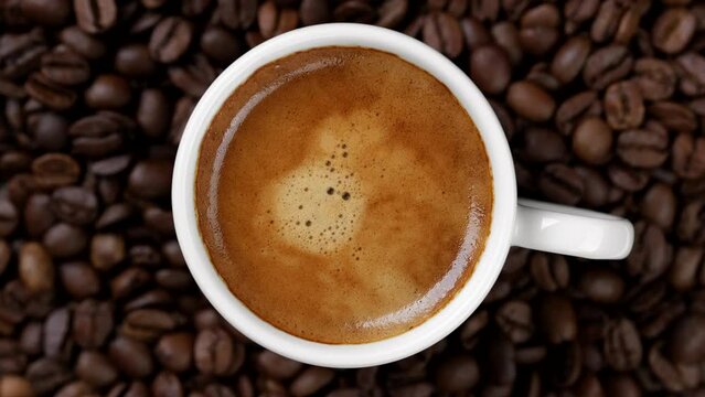 Cup of coffee top view, roasted coffee beans on background