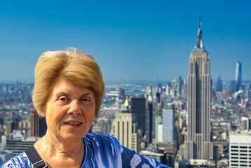 A happy elderly woman looking at New York panorama